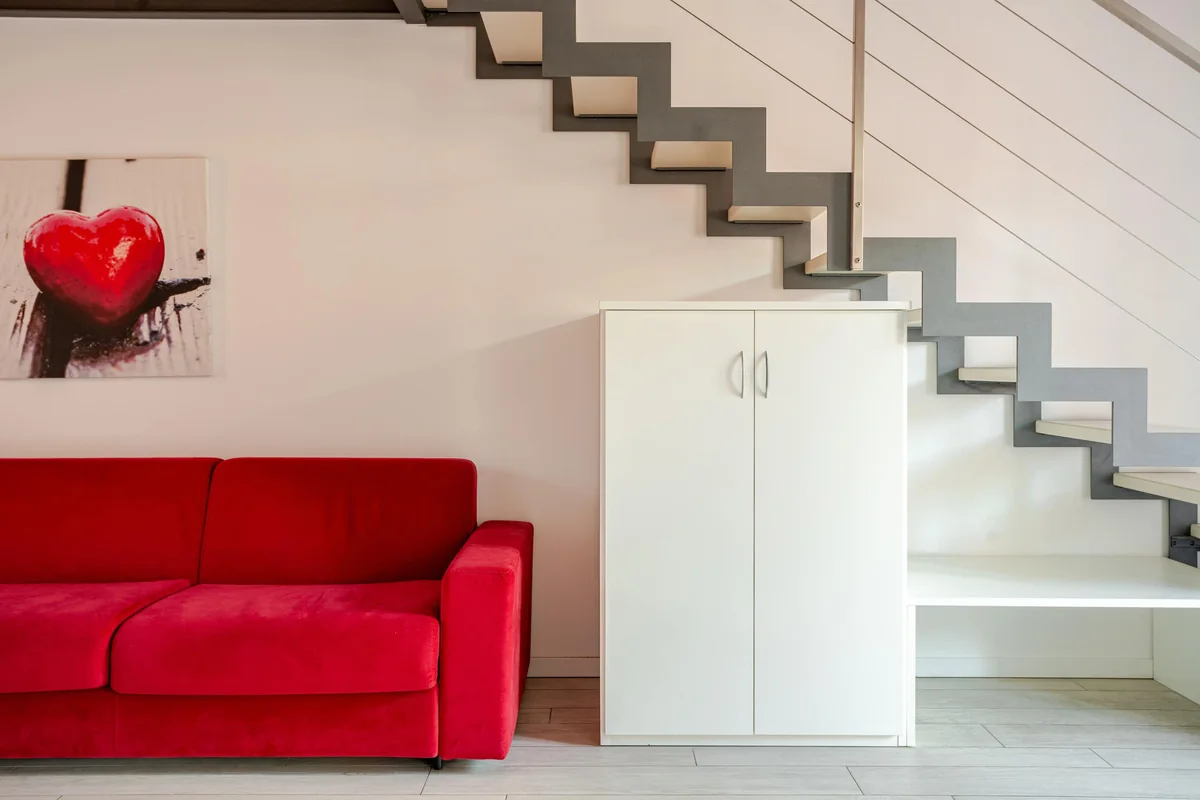 Il divano rosso sotto la scala