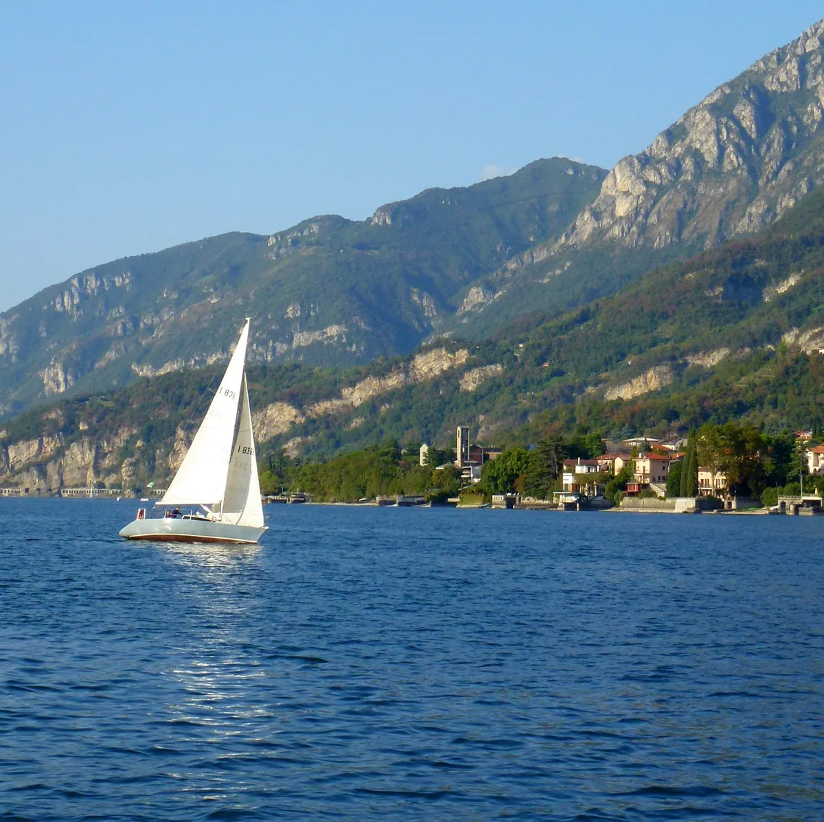 Una barca a vela davanti a Mandello